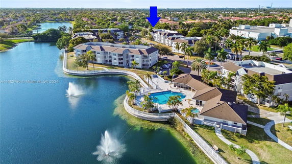Aerial view of a residential complex with a swimming pool next to a lake.