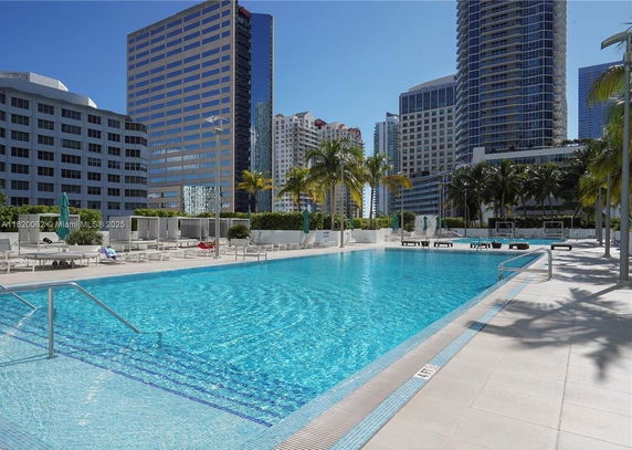 Outdoor swimming pool area surrounded by high-rise buildings.