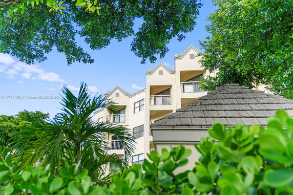 View of a multi-story building with balconies and gabled roof sections.