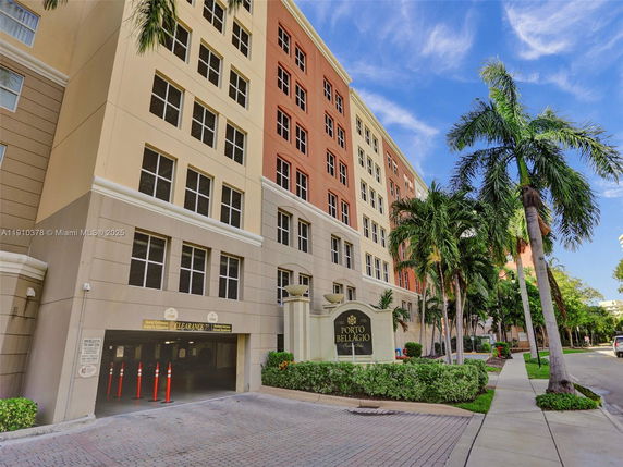 Front view of a multi-story building with a parking entrance.