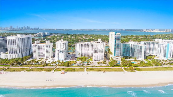 Coastal view of multiple high-rise buildings along a sandy beach.