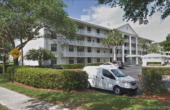 Front view of a multi-story residential building with balconies and columns.