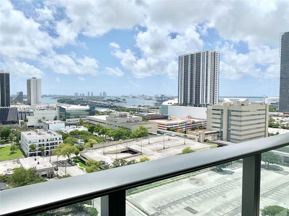 Panoramic view of urban skyline with buildings and distant water body.