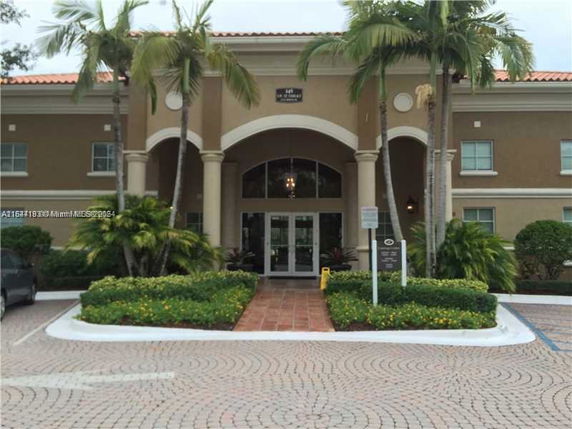 Front view of a building with columns and arched entrance.