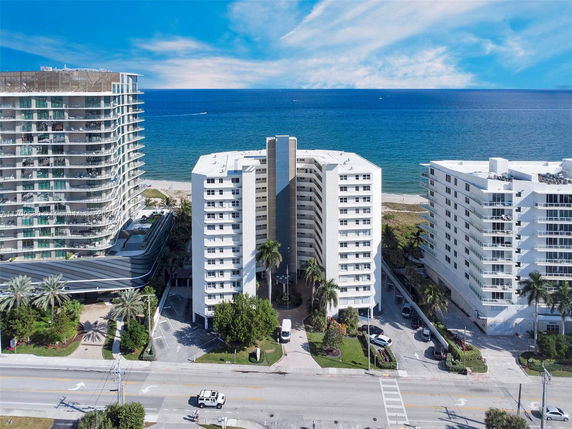Aerial view of beachfront buildings with ocean in the background.
