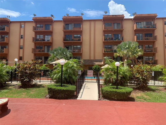 Front view of a multi-story apartment building with balconies.