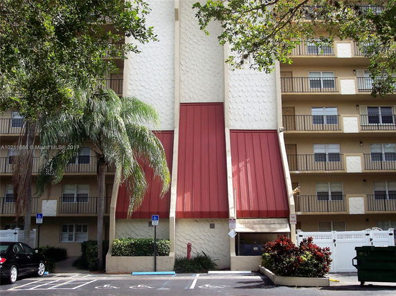 Front view of a multi-story building with a distinct red and white facade.