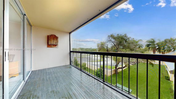 View from a balcony overlooking a grassy area and trees.