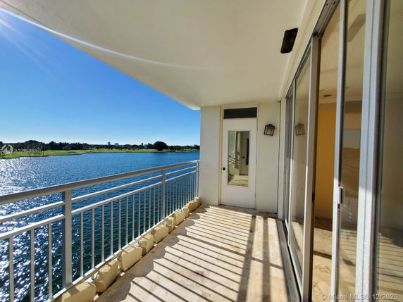 Balcony view overlooking a large body of water and distant landscape.