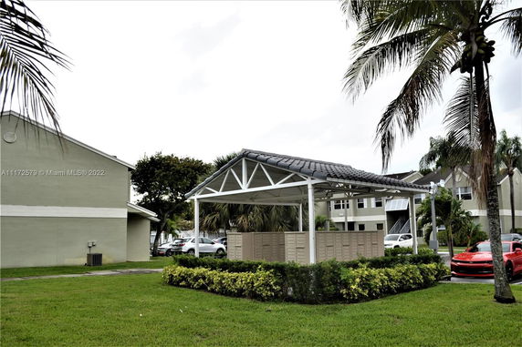 Outdoor view showing multiple residential buildings and a structure housing mailboxes.