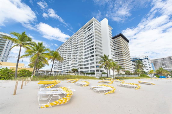 Front view of a tall, multi-story beachfront building with balconies.