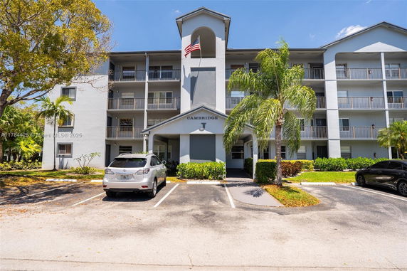 Front view of a multi-story apartment building with a central entrance and balconies.
