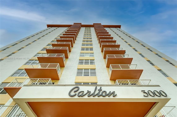 Front view of a tall apartment building with multiple balconies.