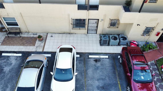 Outdoor parking area with cars and a building entrance.