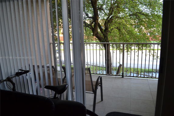 View from a balcony looking out to a tree-lined street.