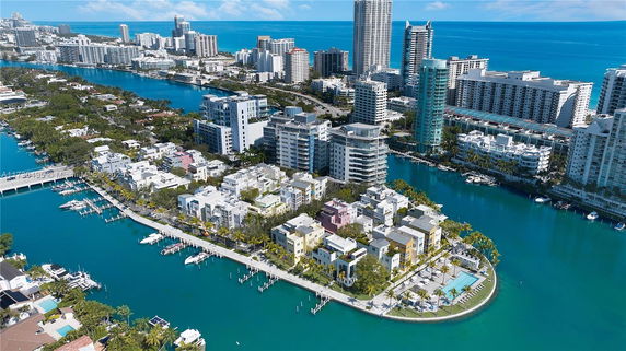 Panoramic view of a waterfront cityscape with modern buildings and waterways.