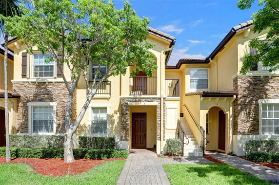 Front view of a two-story house with stone and stucco exterior.