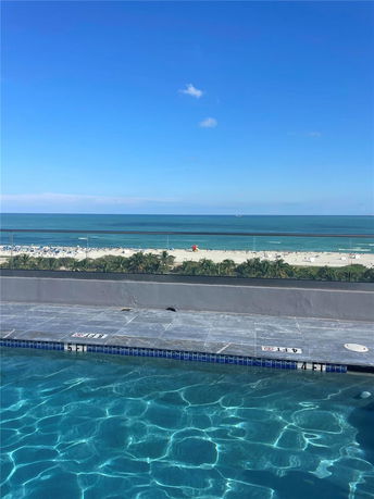 View of a swimming pool overlooking the ocean.