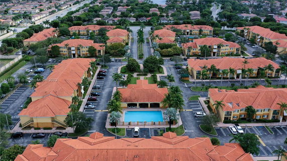 Aerial view of a housing complex with multiple buildings and a swimming pool.