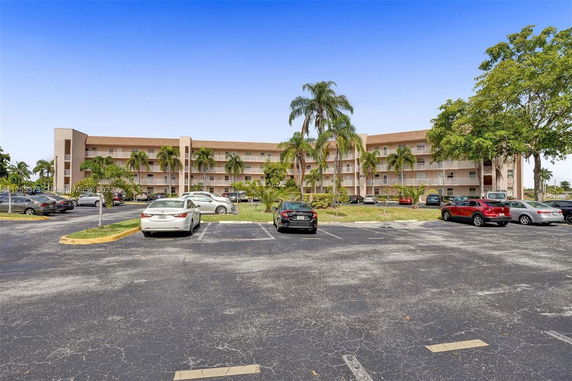Parking area in front of a multi-story residential building.
