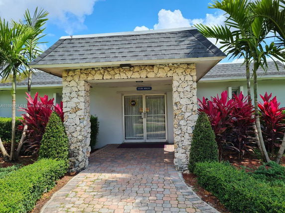 Front view of a house with a decorative stone pillar entrance and a shingled roof.