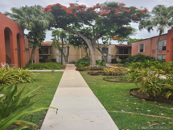 View of residential buildings with a walkway and garden area.
