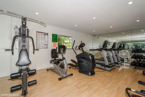 Indoor gym with exercise equipment including treadmills, stationary bikes, and weights.