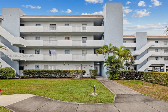 Front view of a multi-story apartment building with balconies.