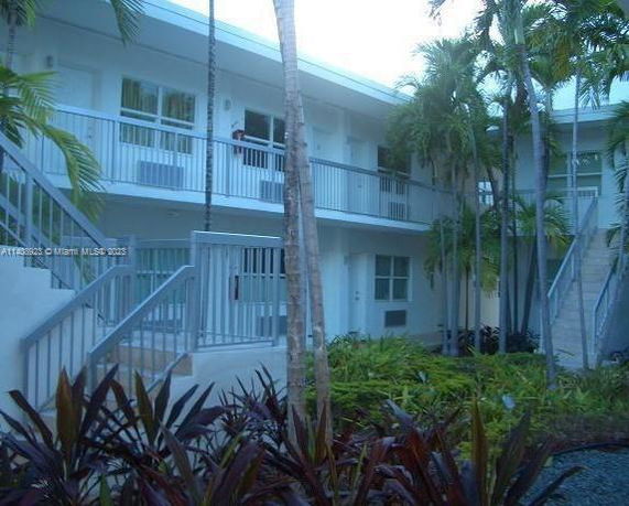 Front view of a two-story apartment building with exterior staircases and balconies.