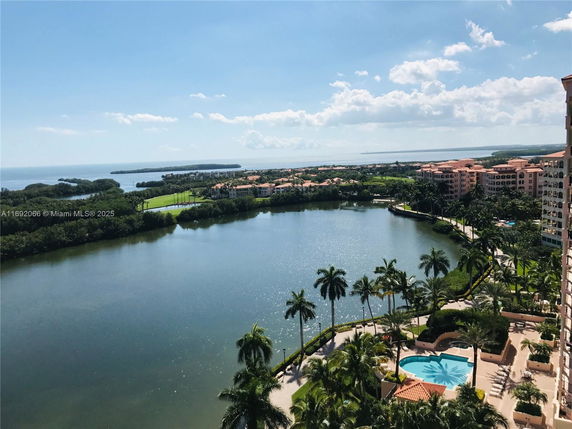 Panoramic view of a lake surrounded by residential buildings and greenery.