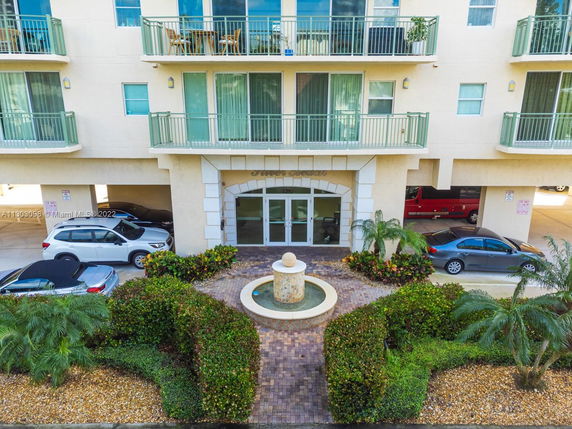 Front view of a multi-story building with balconies and a central entrance.