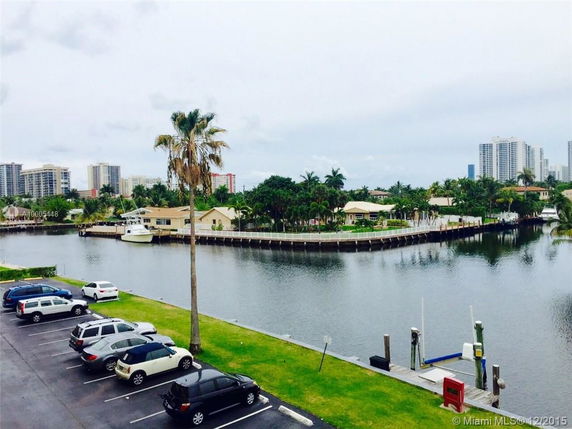 View of waterfront properties with surrounding buildings and parked cars.