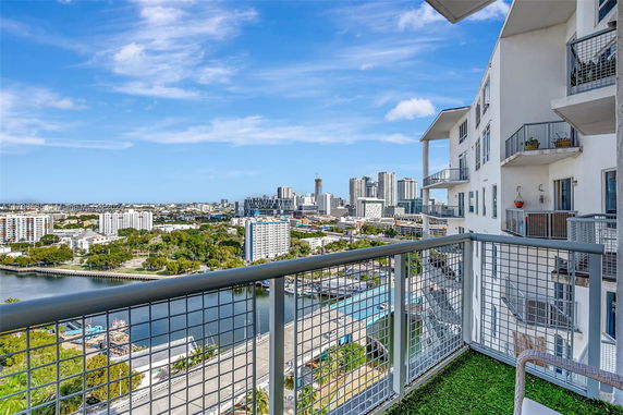 View from a balcony of a multi-story residential building overlooking a cityscape.