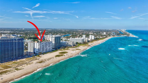 Aerial view of a coastal city with multiple high-rise buildings along a beach.