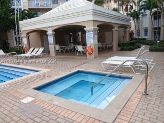 Outdoor swimming pool area with a small hot tub and a covered seating area.