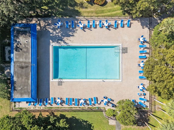 Aerial view of an outdoor swimming pool with surrounding lounge chairs and umbrellas.