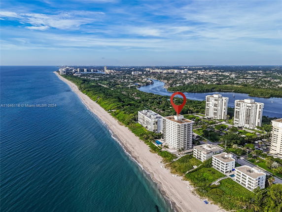 Wide-angle view of a coastline featuring several high-rise residential buildings along the beachfront.