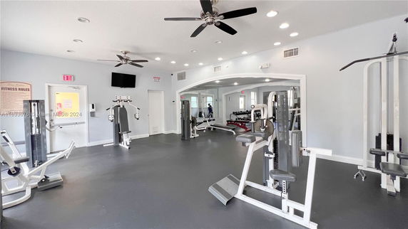 Indoor gym area with exercise equipment and mirrors.