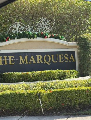 Front view of a decorative entrance sign with a holiday theme.