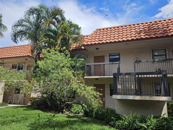 Front view of a two-story building with balconies and a tiled roof.
