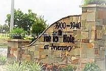 Stone entrance sign with text and surrounding greenery.