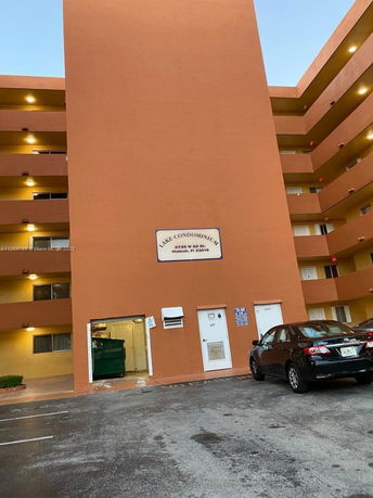Parking area in front of a multi-story condominium building.
