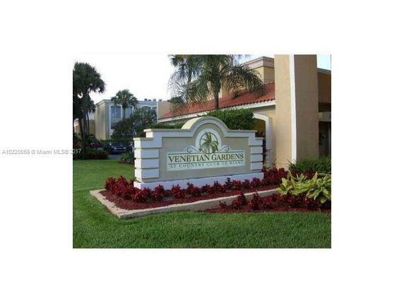 Front view of a building with a sign reading 'Venetian Gardens' and surrounding landscaping.