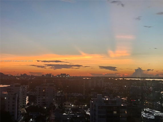 Panoramic view of a cityscape at sunset from a high vantage point.