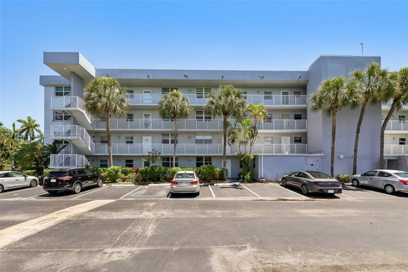Front view of an apartment building with multiple levels and balconies.