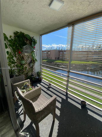 Balcony view with outdoor furniture and landscape in the background.