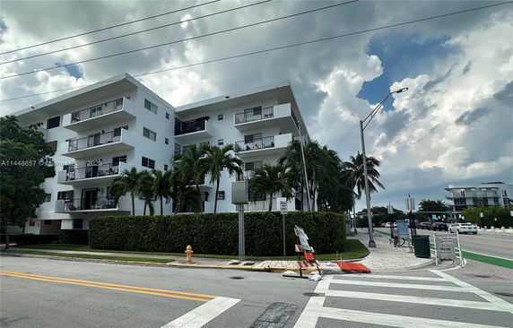 Front view of a multi-story apartment building with balconies.