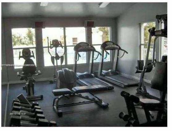 Room equipped with exercise machines including treadmills and stationary bikes.