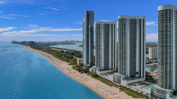 Aerial view of tall beachfront buildings along a coastline with a beach and ocean.