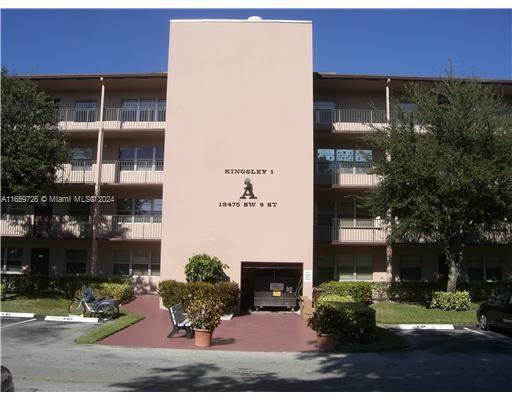 Front view of a multi-story residential building with a central covered entrance.